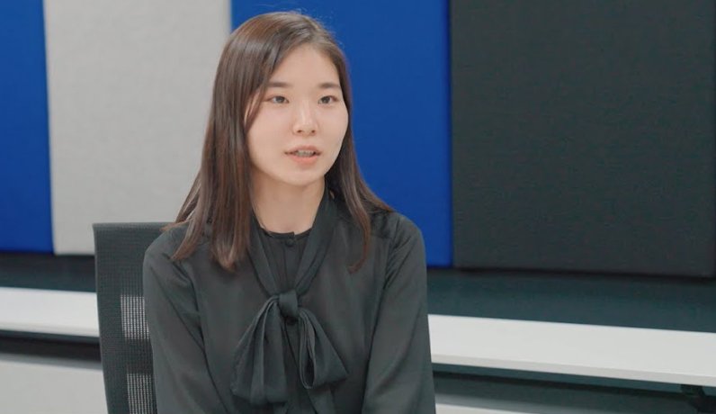 正面を向いて座る社員の女性