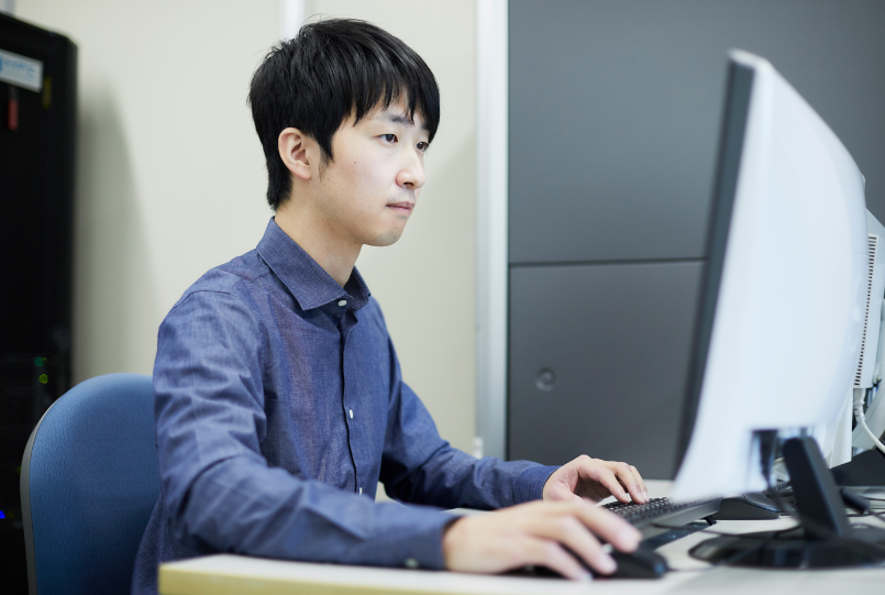 パソコンで作業する横山 智康さん