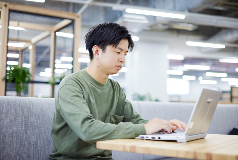 社内でノートPCに向かう松村さん