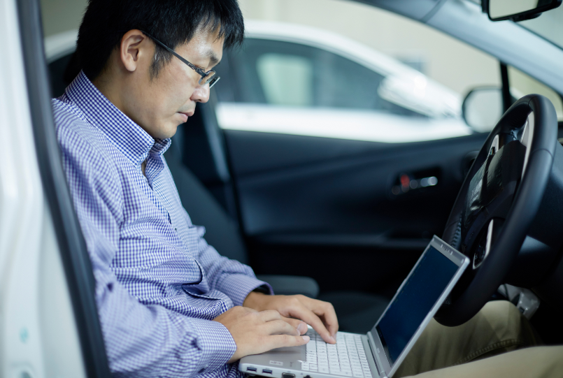 車内でパソコンを操作する岸川 剛さん