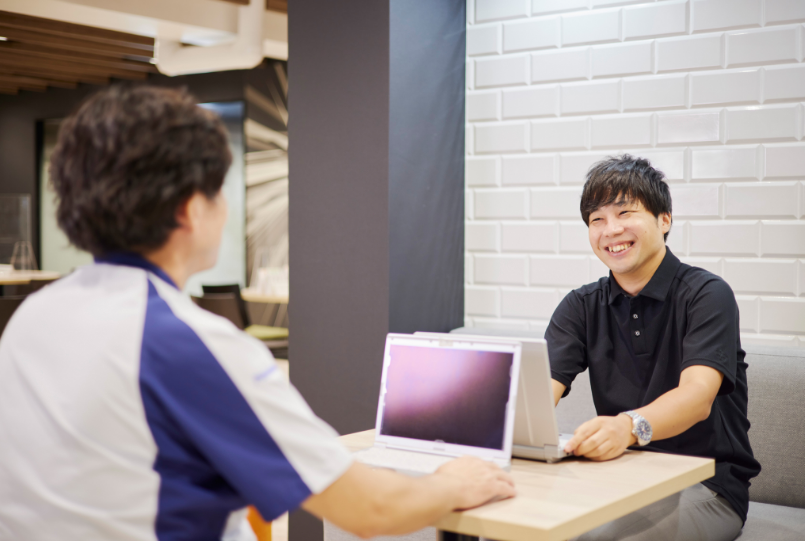 笑顔で打ち合わせをする門田さん