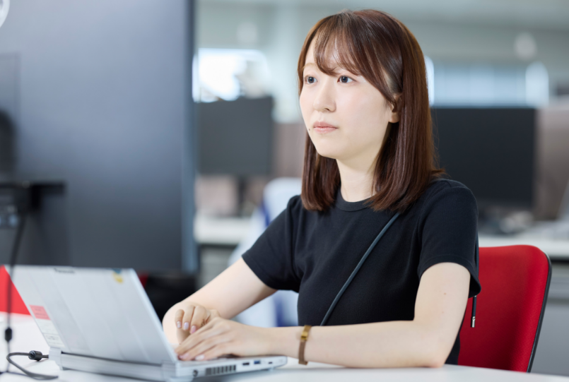 PC作業中の飯田さん